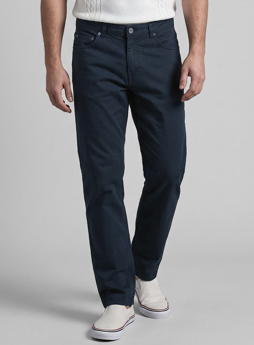Front view of a man wearing dark blue stretch chino jeans, five-pocket style