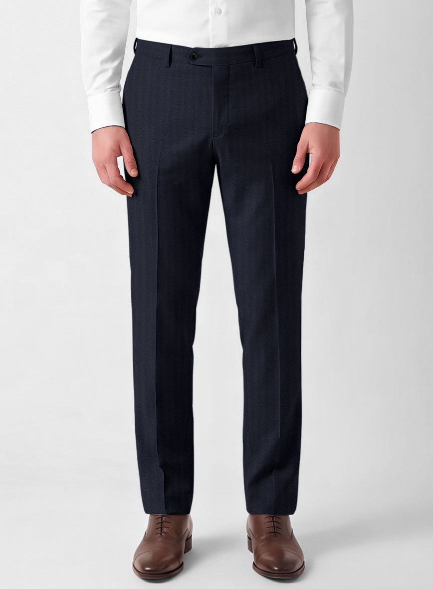 Man wearing navy blue herringbone wool trousers with a white shirt and brown leather shoes, front view
