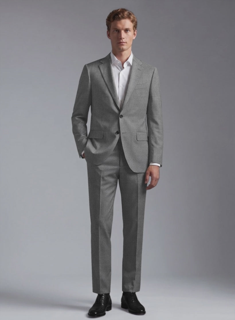 Man wearing a grey wool suit with two-button jacket, hand in pocket, front view