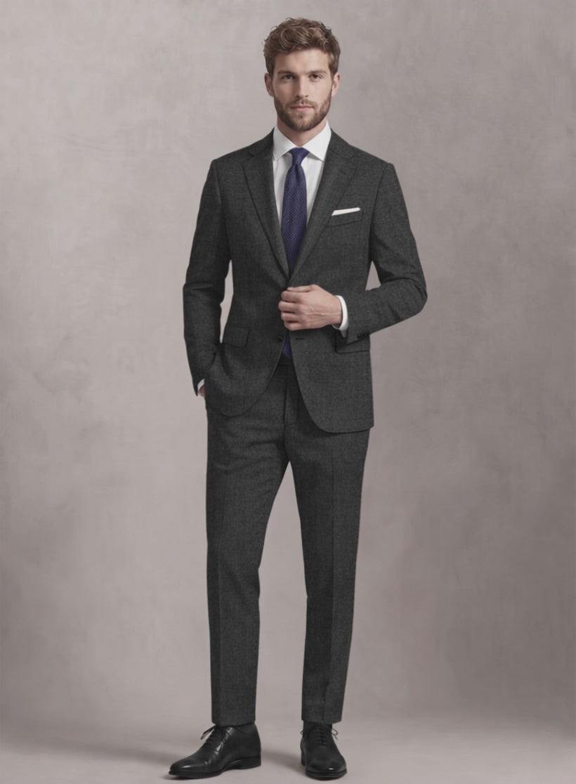 Man wearing a charcoal grey tweed suit with purple tie and pocket square